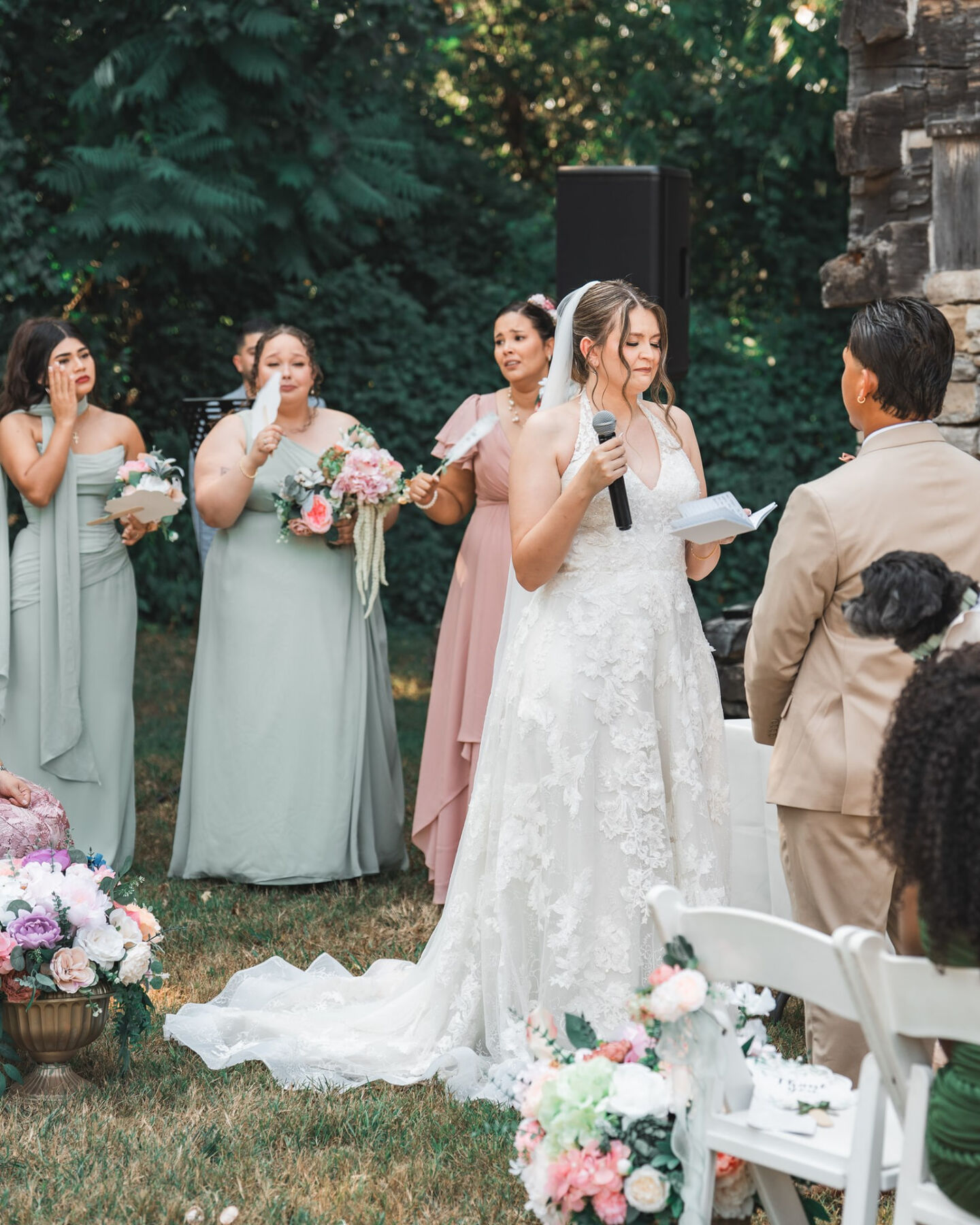 Bride reading her vows while bridesmaids wipe away tears
